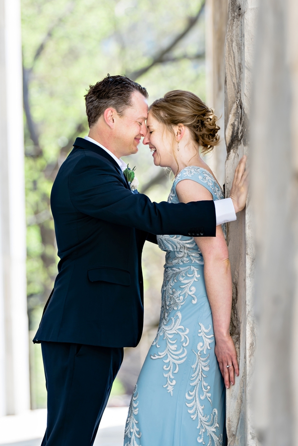 A wedding couple laughing on the steps of the second bank of America.